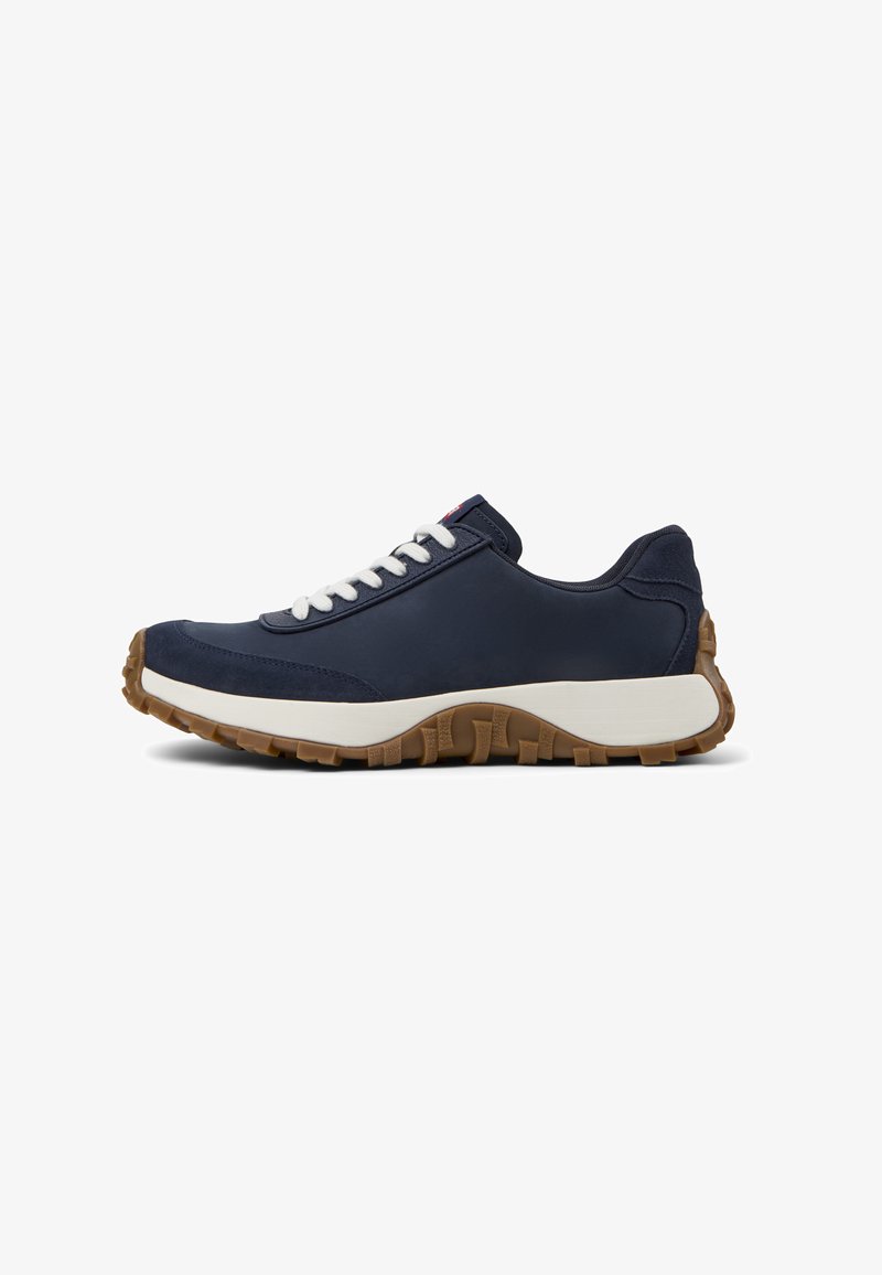 Marineblauwe sneaker met witte veters, gestructureerde suède accenten, rubberen buitenzool en een gevoerde tussenzool voor comfort en ondersteuning.