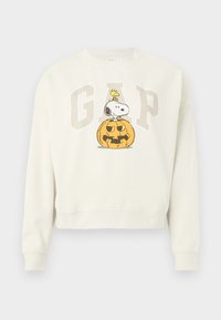 Εκρού φούτερ με το γράμμα "GAP", με τον Snoopy και τον Woodstock σε σχέδιο με κολοκύθα για το Halloween.