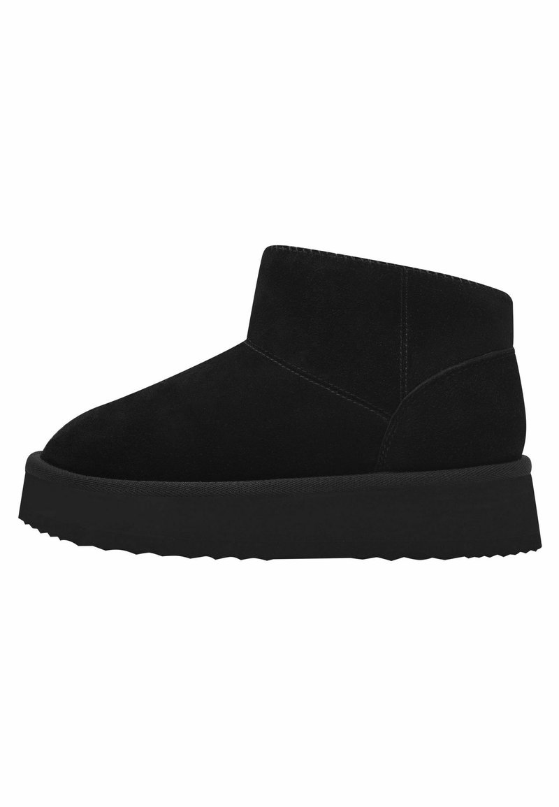 Bottines en suede noir avec une semelle en caoutchouc plate, présentant un bout rond et un design minimaliste. Texture lisse avec une silhouette simple et épurée.
