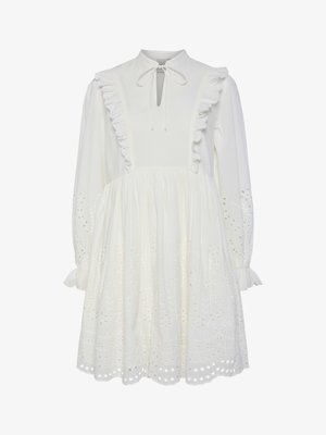 Hvid bomulds kjole med høj hals, flæsekanter og knyttet halsdetalje. Har lange ærmer og broderede øjenlidsmønstre i kanten.