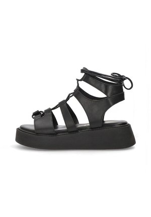 Sandalias de plataforma negras con diseño de punta abierta, fabricadas en suave cuero sintético, que presentan múltiples correas y una suela de goma texturizada.