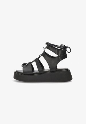 Sandalias de plataforma negras con diseño de punta abierta, fabricadas en suave cuero sintético, que presentan múltiples correas y una suela de goma texturizada.