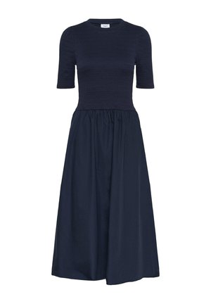 Mørkeblå kjole med korte ærmer, smocket overdel og let skørt. Lavet af åndbart stof med en glat tekstur.