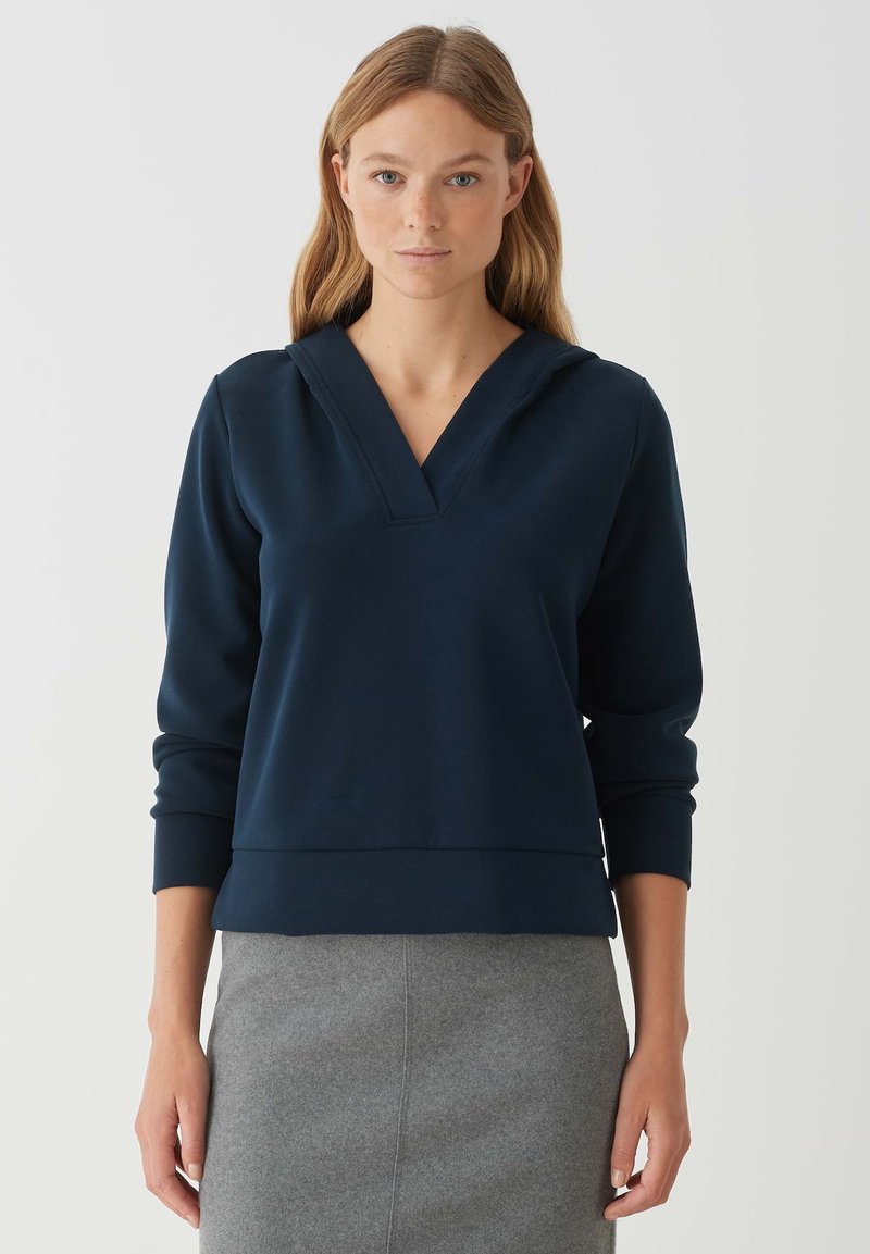 Sweatshirt bleu marine avec un col en V, des manches longues et une coupe décontractée. Fabriqué en tissu doux avec des poignets et un ourlet côtelés.