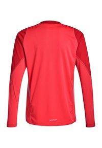 Rotes langärmliges Sportshirt aus leichtem Material, mit einem runden Ausschnitt, strukturierten Einsätzen und reflektierenden Details an den Seiten.