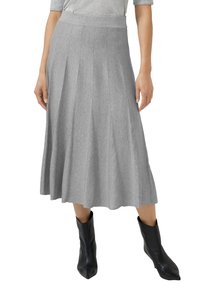 Szara plisowana spódnica o gładkiej fakturze i szerokim pasie, uzupełniona czarnymi botkami z ostrym noskiem, tworząca swobodną sylwetkę.