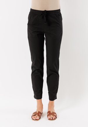 Pantaloni jogger neri in cotone con due tasche frontali, vita elastica e cordoncino, design affusolato e polsini alle caviglie.