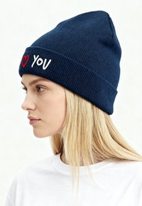 Berretto lavorato a maglia blu navy con risvolto, con ricamo bianco "YOU" e cuore rosso. Tessuto liscio, vestibilità aderente, punta appuntita.