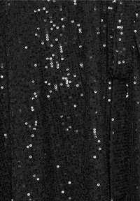 Tissu noir soigneusement recouvert de paillettes noires et argentées brillantes créant une texture scintillante.