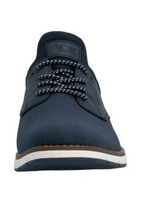 Marineblaue Turnschuh mit gemusterten Schnürsenkeln, strukturiertem Stoffobermaterial und weißer Sohle, von vorne gesehen mit dem Markenlogo auf der Zunge.