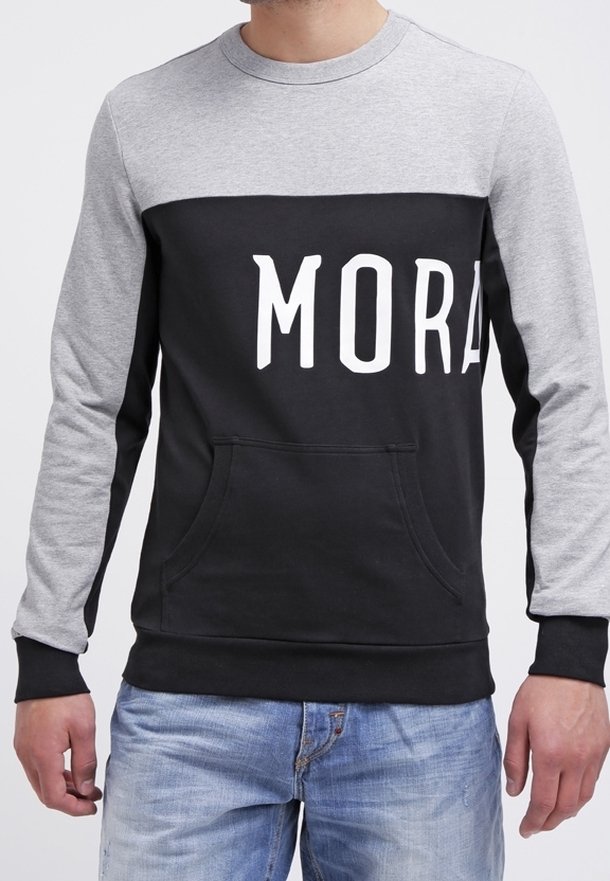 Sweat-shirt noir et gris à manches longues, avec une poche avant et le texte blanc "MORA" sur la poitrine. Matière en mélange de coton.