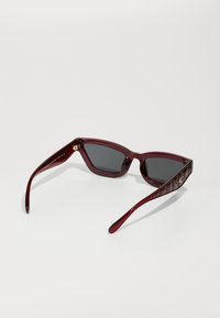 COACH Aurinkolasit - transparent deep red
