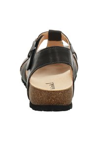 Schwarze Ledersandale mit Korkfußbett, offener Ferse und verstellbarem Riemen. Texturisierte Gummisohle für Grip und Stabilität.