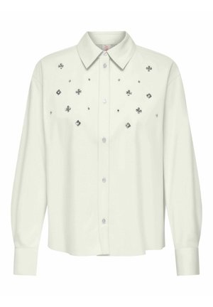 Valge nööbiga särk, millel on pikad varrukad, krae ja kaunistused, sealhulgas erineva suurusega hõbedased nupud ja lillemotiivid.