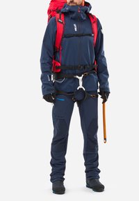 Wodoodporna granatowa kurtka z czerwonymi akcentami, uprząż oraz rękawice; dopasowane niebieskie spodnie; wyposażona w czekan; wytrzymałe obuwie.