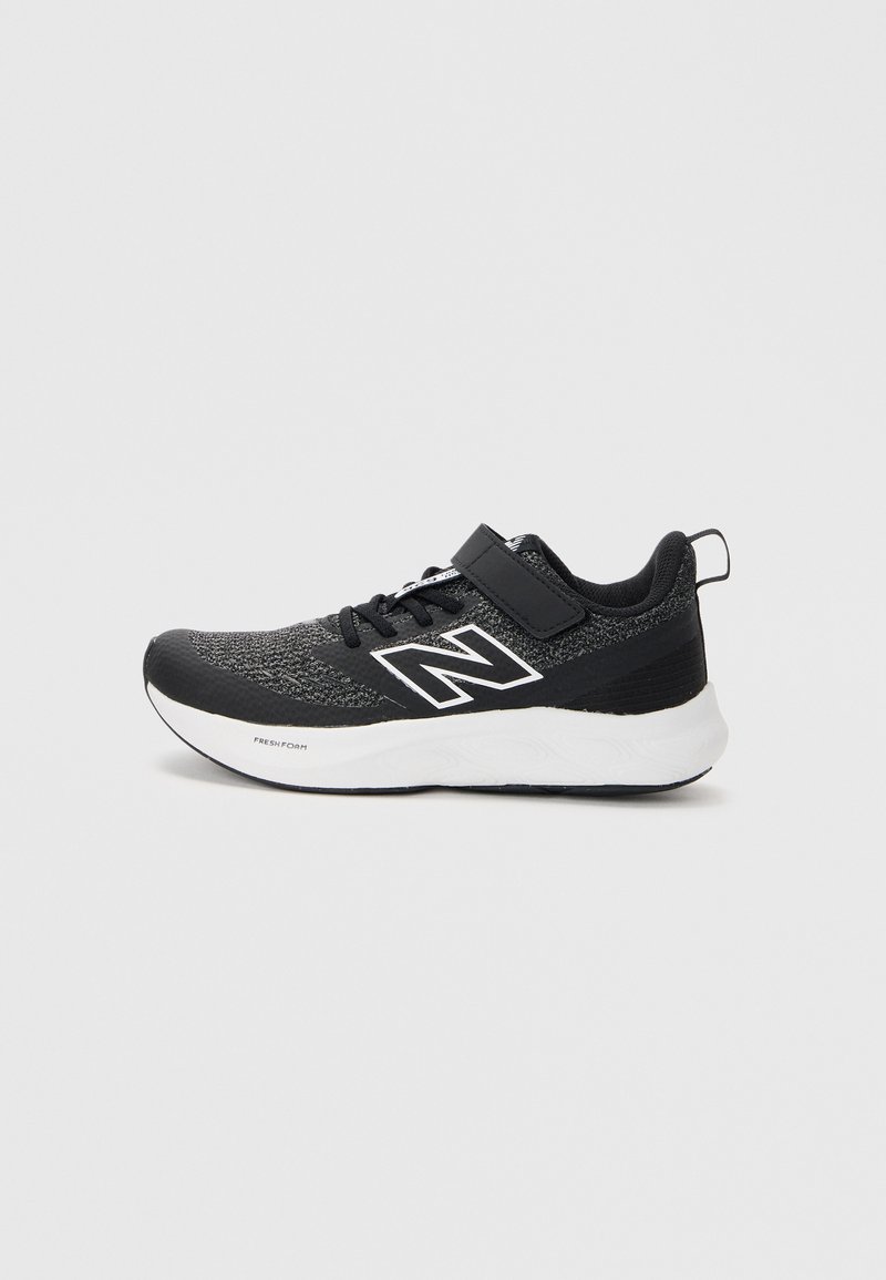 Chaussure de sport noire avec une tige texturée, accents blancs et une sangle sur les lacets. Elle présente une semelle rembourrée pour plus de confort.
