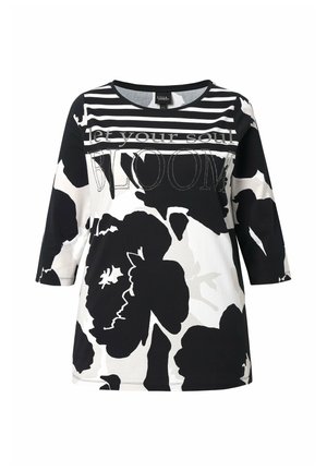 Sort-hvid blomstrede skjorte med 3/4 ærmer, stribet halsudskæring og teksten "lad din sjæl BLOMSTRE" hen over brystet.