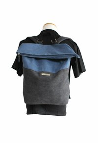 Backpack with a blue upper section and dark gray bottom; made of textured fabric with a zipped top and metal hardware accents.