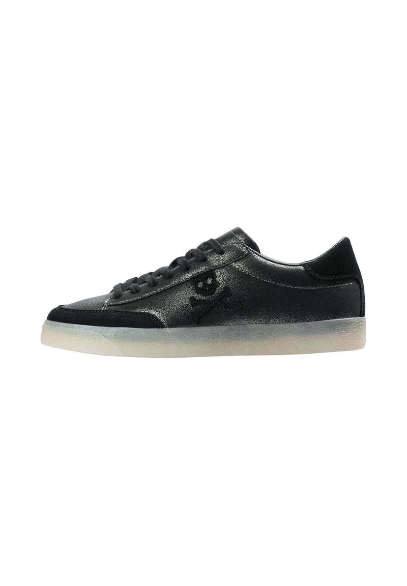 Zapatilla negra de corte bajo con acabado mate, diseño de cordones, detalle de calavera y huesos cruzados en el costado, y suela semi-translúcida de color claro.