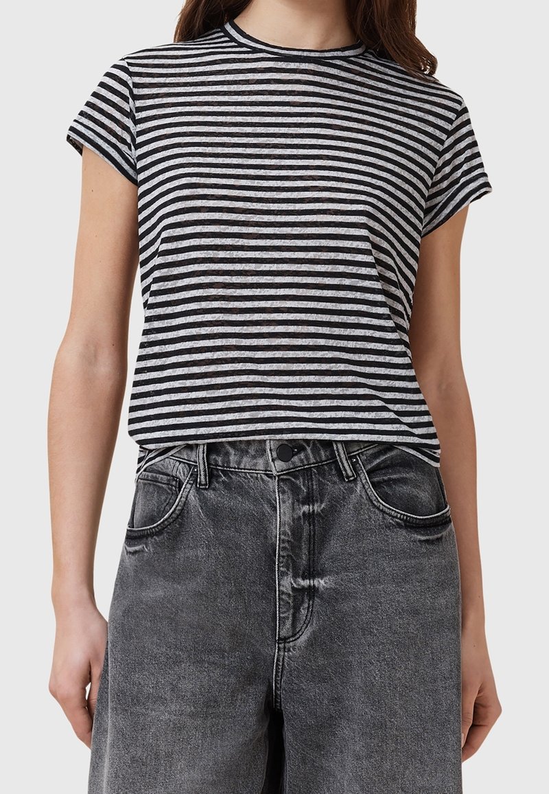 T-shirt rayé noir et blanc, encolure ronde, manches courtes, associé à un jean en denim noir délavé taille haute.
