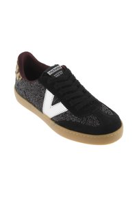 Baskets noires avec surface pailletée, accents en daim, logo blanc et talon en imprimé léopard. Semelle en caoutchouc gomme. Design à lacets avec intérieur rembourré.