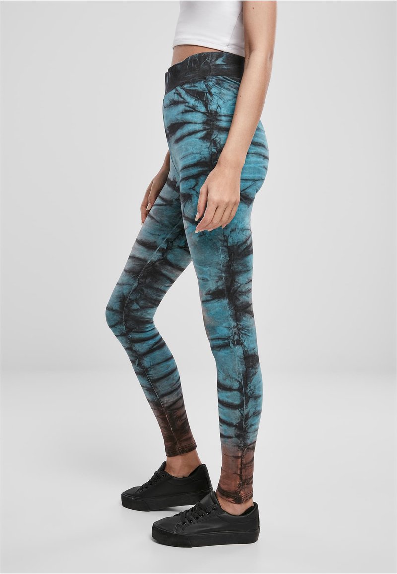 Tajta leggings med ett tie-dye-mönster i turkos och svart, med en mörkbrun övertoning vid vristen. Mjukt, elastiskt material.