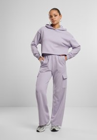 Felpa cropped lilla con tasca a marsupio e pantaloni cargo coordinati a vestibilità rilassata, dotati di tasche laterali e una vita comoda.