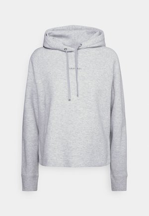 Jasnoszara bluza z kapturem z długim rękawem, z troczkami, małym logo "Calvin Klein" na środku i luźnym krojem na jednolitym tle.