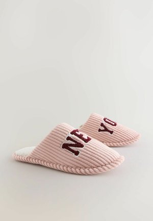 Pantofole in tessuto ribbed rosa con fodera in pile bianco, lettere ricamate che spellano "NEW" a sinistra e "YOU" a destra.