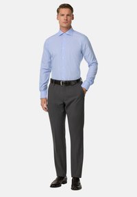 Gaiši zils svītrainais pusgājes krekls ar apkakli, apvienots ar tumši pelēkiem svārkiem un melnām ādas kurpēm. Pielāgota piegriezums, gluda auduma.