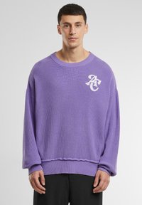 Lila gestrickter Pullover mit lockerer Passform, gerippten Bündchen und Saum, mit einem weißen Logo-Akzent. Texturiertes Material mit einem entspannten Design.