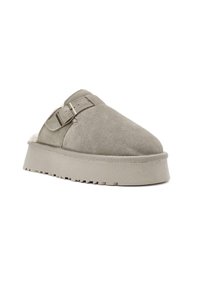Scarpa slip-on in suede grigio chiaro con superficie testurizzata, suola piatta e un accento con cinturino regolabile. Presenta un rivestimento morbido.
