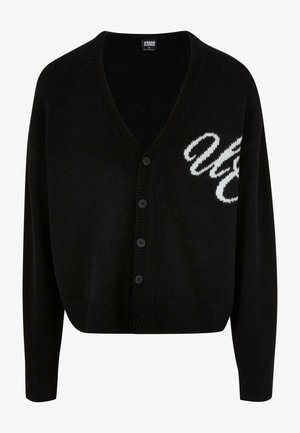 Sort strikket cardigan med v-hals, knaplukning og ribbede manchetter. Broderet hvid skrift på venstre side, cropped pasform.