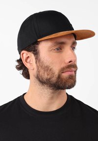 Casquette de baseball en tissu noir avec une visière en bois plat, présentant une finition texturée et un logo subtil sur le devant.
