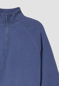 Blauwe sweatshirt met rits en ronde hals, voorzien van een geribde kraag, raglanmouwen en een textielstructuur, ontworpen voor comfort en casual gebruik.
