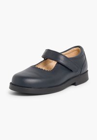 Zapato de cuero azul marino con puntera redondeada y detalles en forma de ondas, que cuenta con una correa de Velcro para un ajuste seguro y una suela de goma plana.