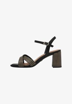 Black heeled sandals with a wide cross strap design, a textured pattern on the upper, and a block heel. Adjustable ankle strap with buckle.