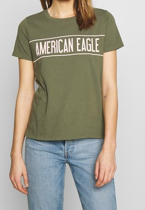 Oliwkowo-zielona bawełniana koszulka z krótkimi rękawami, okrągłym dekoltem oraz różowym nadrukiem "AMERICAN EAGLE" na środku klatki piersiowej.