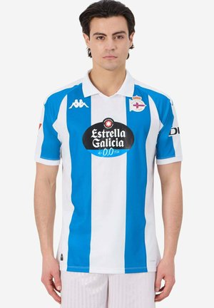 Maglia sportiva a righe bianche e blu con colletto. Presenta un logo centrale in un design circolare e branding sulle maniche. Realizzata in tessuto traspirante.