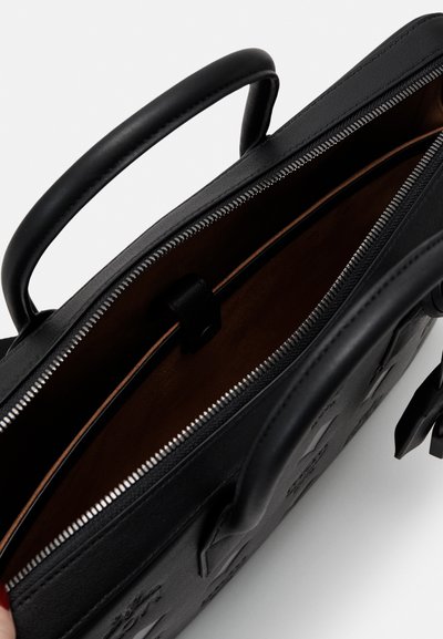 Sac en cuir noir avec une fermeture éclair, poches intérieures et extérieur texturé. Doté de poignées courtes et d'une doublure lisse.