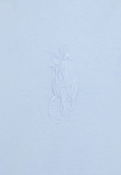 Svijetloplava pamučna majica s diskretnim, toniranim vezenim dizajnom konja i jahača koji igra polo. Glatka tekstura, klasičan kroj.