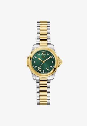 Guld- og sølvfarvet rustfri ståleur med grøn urskive, romertal, diamantdetaljer og en krone på siden. Armbånd med led-design.
