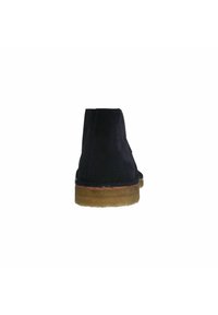 Bottes de cheville en suede bleu marine avec un bout rond, semelle en caoutchouc beige clair et détails de couture sur les côtés et à l'arrière.