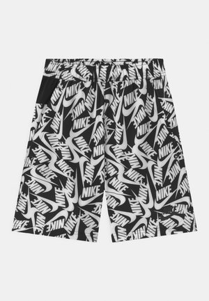 Pantalones cortos en blanco y negro con cintura elástica, cubiertos de logotipos de Nike superpuestos y patrones de swoosh.