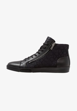 Zapatilla deportiva negra de caña alta con cremallera lateral, cordones en la parte delantera, tejido con patrón de marca y detalles de cuero en los dedos y el talón.