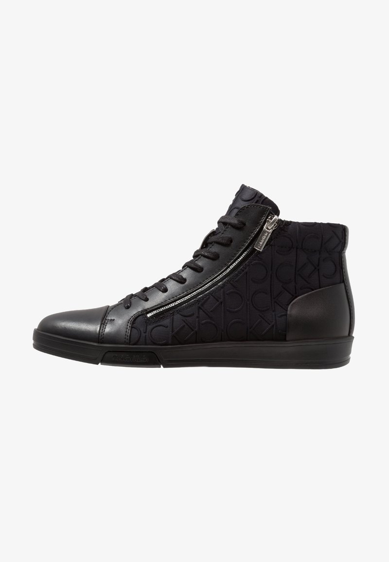 Baskets montantes noires avec fermeture éclair sur le côté, lacets à l'avant, tissu à motif de marque et détails en cuir au niveau des orteils et du talon.