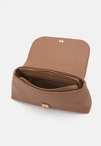 Borsa a tracolla in pelle marrone con finitura texturizzata, scomparti con zip e una chiusura a pattina con clasp in tono oro. L'interno presenta numerose tasche.