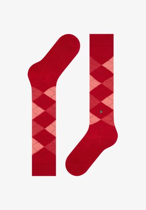 Calcetines de patrón argyle en rojo y rosa con una textura suave. Presentan la puntera y el puño en un rojo sólido, además de un pequeño detalle en metal con el logo en el lateral.