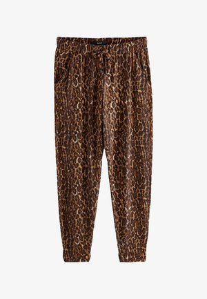 Close-up van bruine en zwarte broek met luipaardprint, trekkoord in de taille en zijzak, gedragen met een zwarte top en een beige jas.