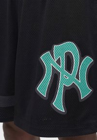 Μαύρο δίχτυ σορτς με μεγάλο στυλιζαρισμένο λογότυπο "RD" σε τιρκουάζ και λευκό στο κάτω μέρος κοντά στο τελείωμα.